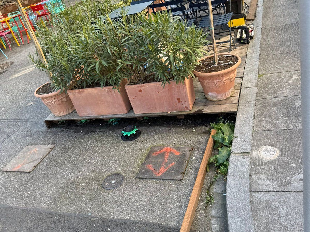 Terrasse existante bordée de jardinières, avant son agrandissement : emplacement tracé au sol et premier plot de support posé sur la rue