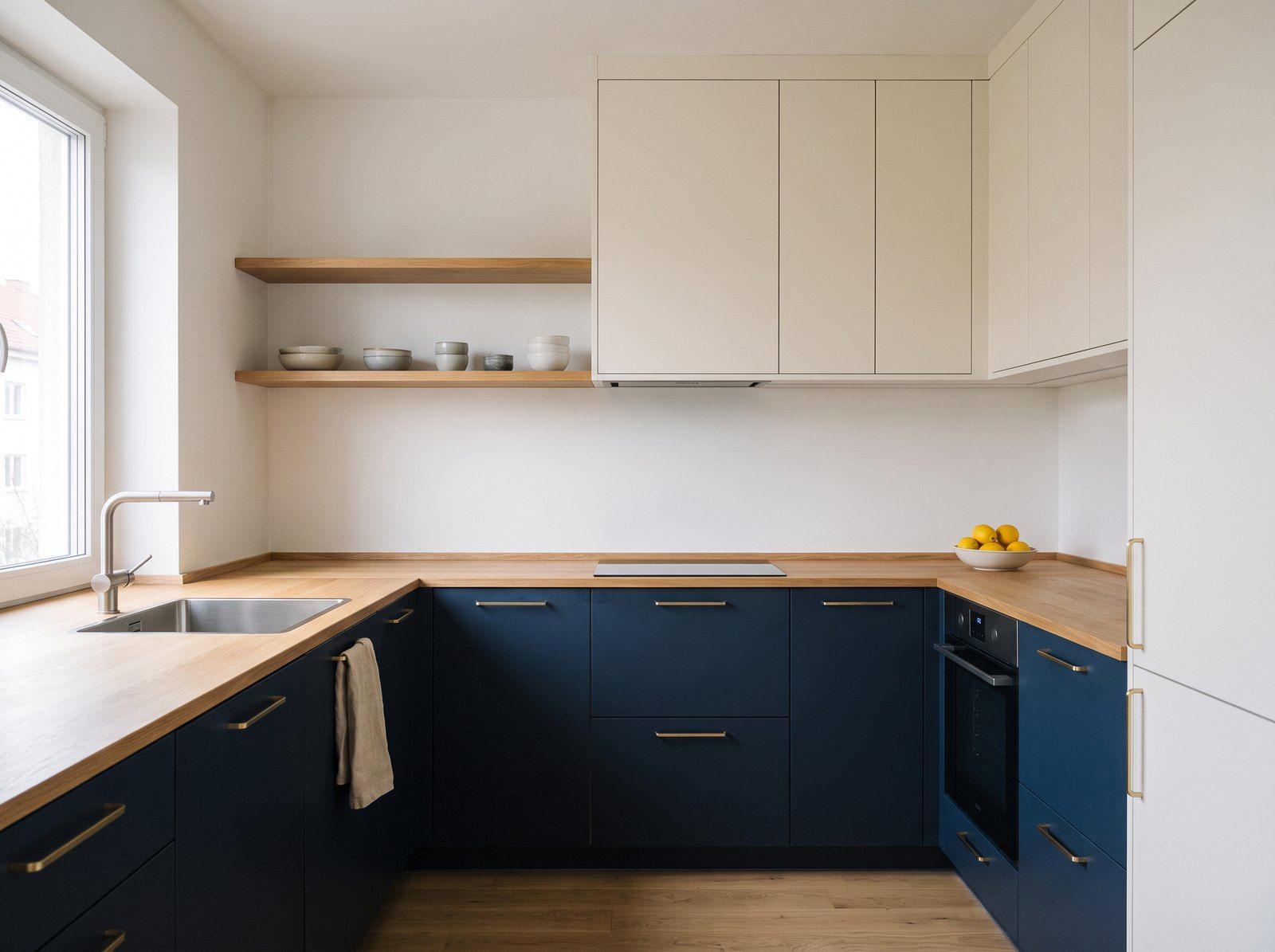 Cuisine en L aux meubles bas bleu marine, colonnes blanches et plan de travail en chêne — image d’illustration
