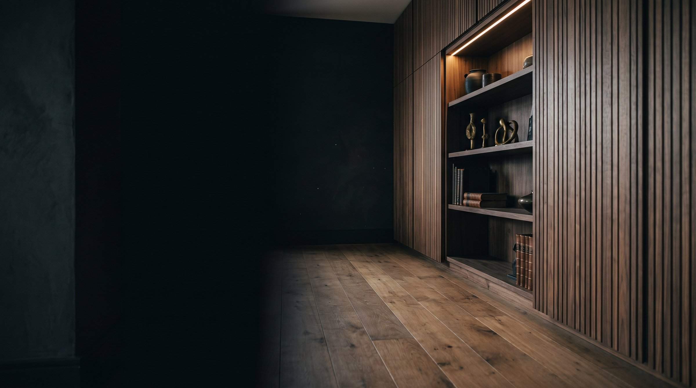 Mur de menuiserie en noyer à tasseaux verticaux avec niche éclairée et parquet en chêne — image d’ambiance