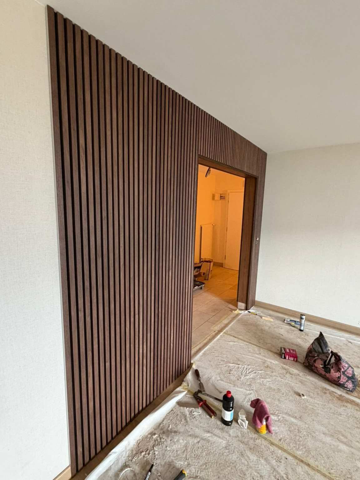 Pose d’un habillage en tasseaux de bois pendant la rénovation d’un appartement à Vevey