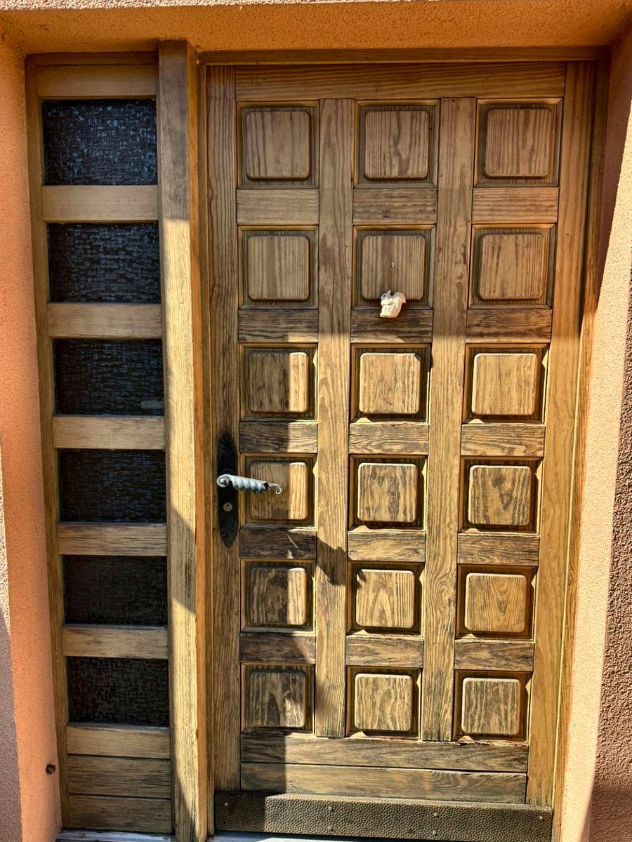 Porte d’entrée en bois verni avant sa rénovation, à Yverdon-les-Bains